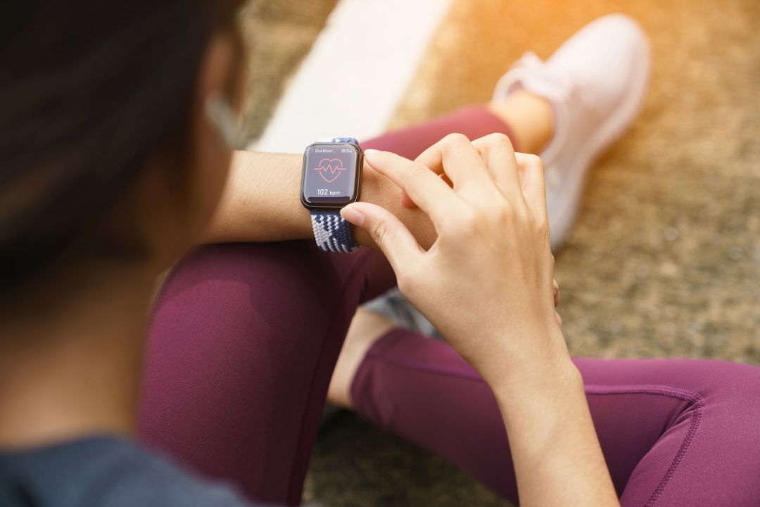 A woman checking the heart rate reading on her smartwatch after exercise
